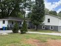 Exterior view of the house showing white siding, a deck, and mature trees at 5460 Huron Dr, Morrow, GA 30260