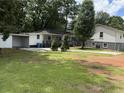 View of the home featuring a carport, small deck, and well-maintained lawn at 5460 Huron Dr, Morrow, GA 30260