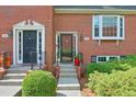 Close-up of a red brick townhome showcasing front door details and manicured landscaping at 701 Dunwoody Chace, Atlanta, GA 30328