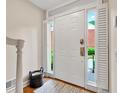 Bright entryway featuring a white front door flanked by shuttered sidelights, hardwood flooring, and a neutral color scheme at 701 Dunwoody Chace, Atlanta, GA 30328