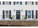 View of the home's entry featuring a black door with a wreath, plants, and black railing at 2284 Briarwood Cir, Conyers, GA 30094