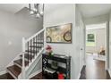 Hallway features a staircase with white railing, hardwood floors, and decorative painting at 2284 Briarwood Cir, Conyers, GA 30094