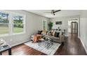 Comfortable living room featuring a decorative ceiling fan, hardwood floors, and lots of natural light at 2284 Briarwood Cir, Conyers, GA 30094