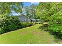 Attractive single-story home surrounded by mature trees and lush landscaping on a well-manicured lawn at 3770 Clubland Trl, Marietta, GA 30068