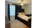 Cozy bedroom featuring a dark wood bed frame, a ceiling fan, and lots of natural light from the window at 320 Orleans Blvd, Mcdonough, GA 30253