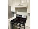 Stainless steel stove and white tile backsplash with white cabinets above and to the side at 320 Orleans Blvd, Mcdonough, GA 30253