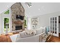 Cozy living room with a stone fireplace, hardwood floors, and ample natural light at 413 Sassafras Rd, Roswell, GA 30076