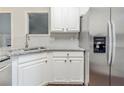 Kitchen showcases stainless steel refrigerator, granite counters and white cabinetry at 5335 Lexington View Pl, Sugar Hill, GA 30518