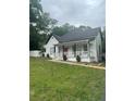 Charming home showcasing a welcoming front porch, red door, and a well-maintained lawn at 6860 Parkway Dr, Lithonia, GA 30058