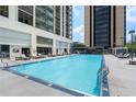 Outdoor pool area featuring lounge chairs for relaxing by the sparkling blue water in a modern community setting at 1280 W Peachtree Nw St # 2409, Atlanta, GA 30309