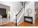 Bright foyer with a staircase featuring white railings and black spindles, complemented by hardwood floors at 58 Parkside Cir, Marietta, GA 30068