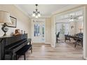 Welcoming entryway with a black piano and an open view to the home office with lots of natural light at 251 Parc Dr, Canton, GA 30114