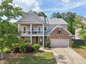Beautiful two-story home with a brick facade, a covered front porch, mature landscaping, and an attached garage at 251 Parc Dr, Canton, GA 30114