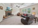 Spacious living room with a stone fireplace, tray ceilings, a ceiling fan, and large windows at 251 Parc Dr, Canton, GA 30114