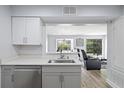 Kitchen area overlooking living room features gray cabinets and stainless steel dishwasher and sink at 2657 Lenox Ne Rd # A-5, Atlanta, GA 30324