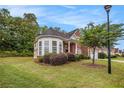 Beautiful brick home with a manicured lawn and mature trees on a sunny day at 3185 Highgreen Trl, Atlanta, GA 30349