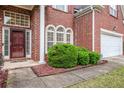 Close-up of a brick home's inviting entrance, landscape, garage and walkway at 3185 Highgreen Trl, Atlanta, GA 30349