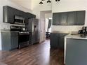 Modern kitchen features dark gray cabinets, stainless steel appliances, granite countertops, and wood flooring at 2945 Dogwood Creek Parkway, Duluth, GA 30096