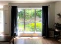Living room featuring a large window and dark curtains with a view of the backyard at 2945 Dogwood Creek Parkway, Duluth, GA 30096