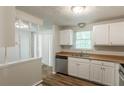 Bright kitchen with white cabinets, stainless steel appliances, and wood-look flooring at 5372 Martins Crossing Rd, Stone Mountain, GA 30088