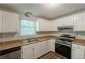 Modern kitchen featuring stainless steel appliances, wood look flooring, and ample cabinet space at 5372 Martins Crossing Rd, Stone Mountain, GA 30088