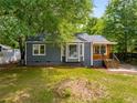 Charming home with a combination of gray siding and natural wood accents, surrounded by mature trees at 638 Medford Se Pl, Smyrna, GA 30080