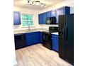 Bright kitchen features granite countertops, stainless steel appliances, and sleek blue cabinetry at 1700 Devon Sw Dr, Atlanta, GA 30311