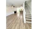 Bright open-concept living room with fireplace, ceiling fan and stairs leading to the second level at 1700 Devon Sw Dr, Atlanta, GA 30311