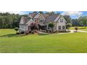 Beautiful two-story home featuring stone accents, manicured landscaping, and a well-maintained lawn at 829 Christopher Rd, Sharpsburg, GA 30277