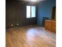 Bedroom featuring wood-look floors, a dark accent wall, and a small window at 286 Toweridge Sw Dr # 3, Marietta, GA 30064
