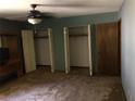 Bedroom with a ceiling fan, dirty carpet, two closets, and a wooden door at 286 Toweridge Sw Dr # 3, Marietta, GA 30064