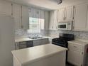 Bright kitchen with white cabinets, modern appliances, and ample counter space at 421 Old Ivy Path, Mcdonough, GA 30253