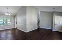 Bright living room with dark wood floors, large windows, and a staircase leading to the upper level at 4827 Wyndam Dr, Stone Mountain, GA 30088