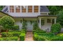This home features a delightful outdoor bench and landscaping with an inviting garden entryway and pristine lawn at 341 Lands Se Ml, Marietta, GA 30067