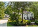 A two-story home with a detached garage surrounded by mature trees and verdant landscaping at 341 Lands Se Ml, Marietta, GA 30067