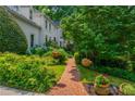 Charming brick walkway leading to a home's entrance, adorned with colorful flowers and lush garden foliage at 341 Lands Se Ml, Marietta, GA 30067