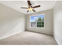 Well-lit bedroom with neutral carpet, a ceiling fan, and a large window at 617 Kyles Cir, Hiram, GA 30141