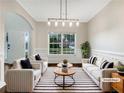 Bright living room with modern lighting, neutral furniture, and a striped rug offers a welcoming space at 617 Kyles Cir, Hiram, GA 30141