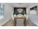Formal dining room with a large table, seating for eight, elegant chandelier, and natural light at 7620 Breeze Bay Rd, Cumming, GA 30041