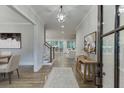 Inviting foyer with hardwood floors, elegant lighting, artwork, and an open view to the living areas at 7620 Breeze Bay Rd, Cumming, GA 30041