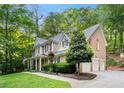 Charming two-story home with a brick exterior, a three-car garage, and a beautifully landscaped front yard at 525 Watergate Ct, Roswell, GA 30076