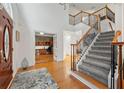 Elegant foyer featuring hardwood floors, a staircase with iron railings, and an adjacent office space at 525 Watergate Ct, Roswell, GA 30076