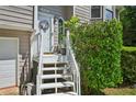 Close-up of the entryway with a decorated front door, white stairs, and lush landscaping at 4035 Woodbridge Ct, Powder Springs, GA 30127