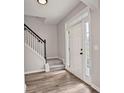Bright foyer showcasing new floors, stairs with a black railing, and natural light from side panel windows around the front door at 463 The Gables Dr, Mcdonough, GA 30253