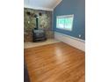 Inviting living area featuring a stone accent wall with a wood-burning stove and laminate floors at 1234 Carolyn St, Marietta, GA 30062