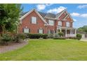 Beautiful two-story brick home with a well-manicured lawn and mature landscaping at 3305 Millwater Xing, Dacula, GA 30019