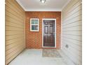 Covered entrance showcasing a brick accent wall and a traditional-style front door at 607 Tall Timbers, Woodstock, GA 30188
