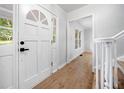 Inviting foyer with wood-look flooring, crisp white trim and staircase, and a charming, decorative front door at 3078 Milford Chase Sw, Marietta, GA 30008