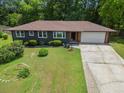 A house featuring well-maintained yard space with a wide driveway leading to an attached garage at 3779 Elkridge Dr, Decatur, GA 30032