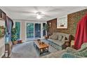 Relaxing sun room features exposed brick wall, neutral carpet, ceiling fan and outdoor access at 200 Dogwood Dr, Canton, GA 30114